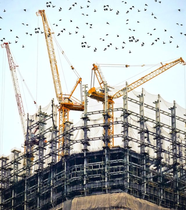 Cranes on top of buildings. Original public domain image from Wikimedia Commons.